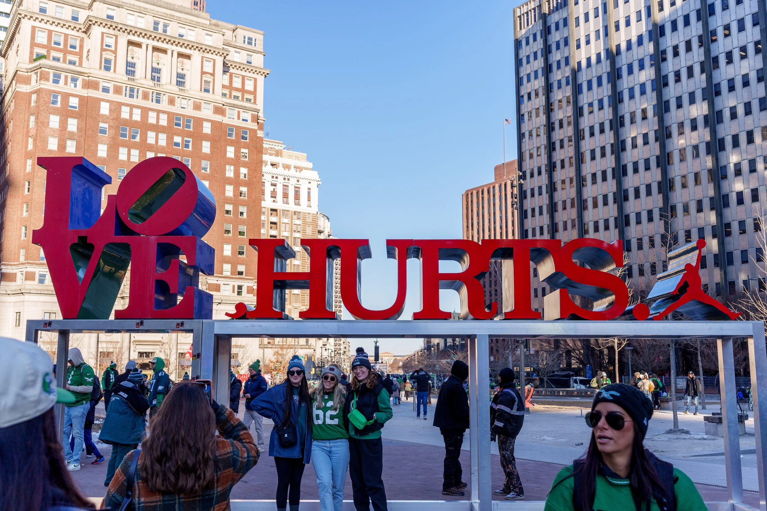 Fans photographing each other in front of the LOVE HURTS. sculpture