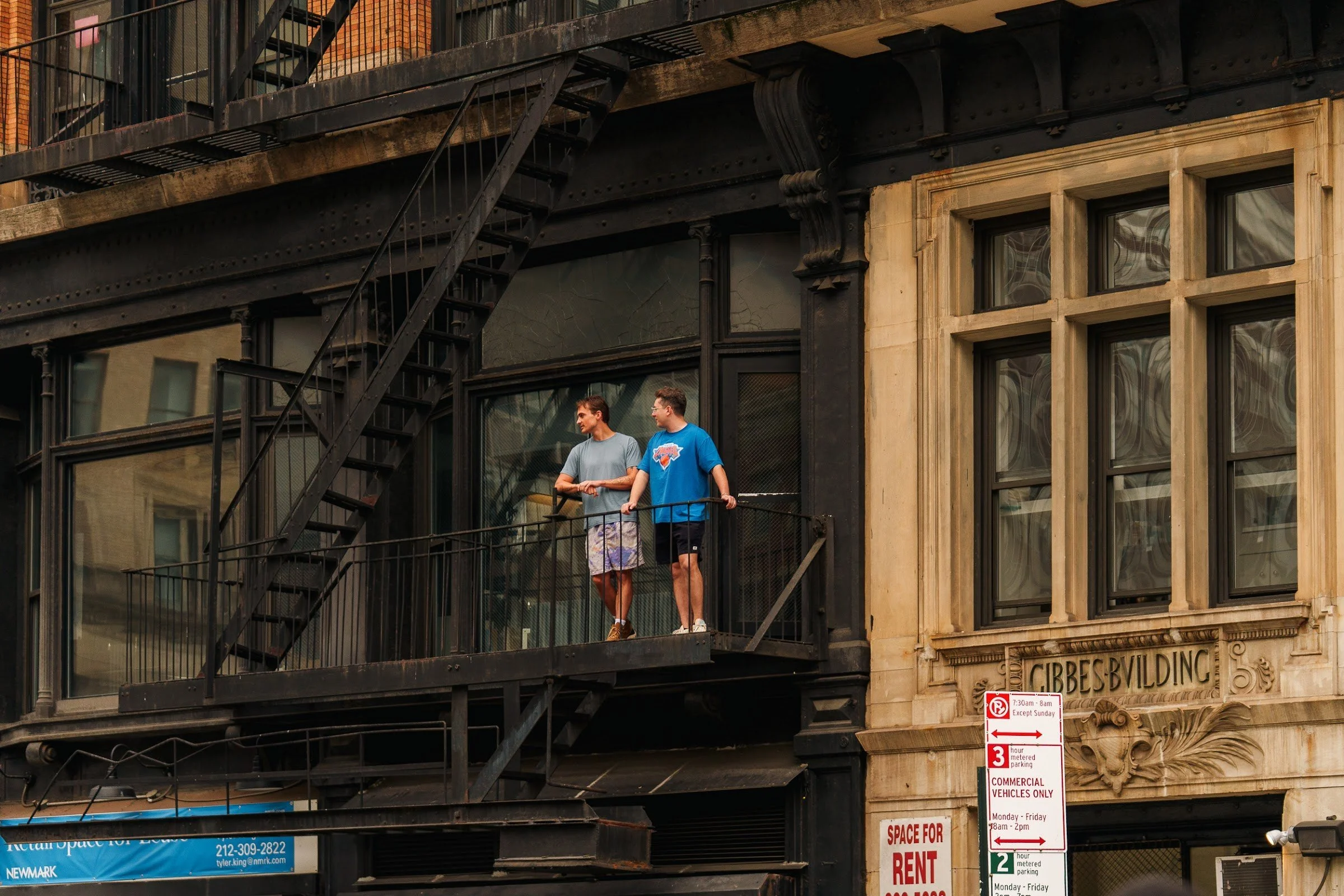 Spectators on a fire escape above the parade
