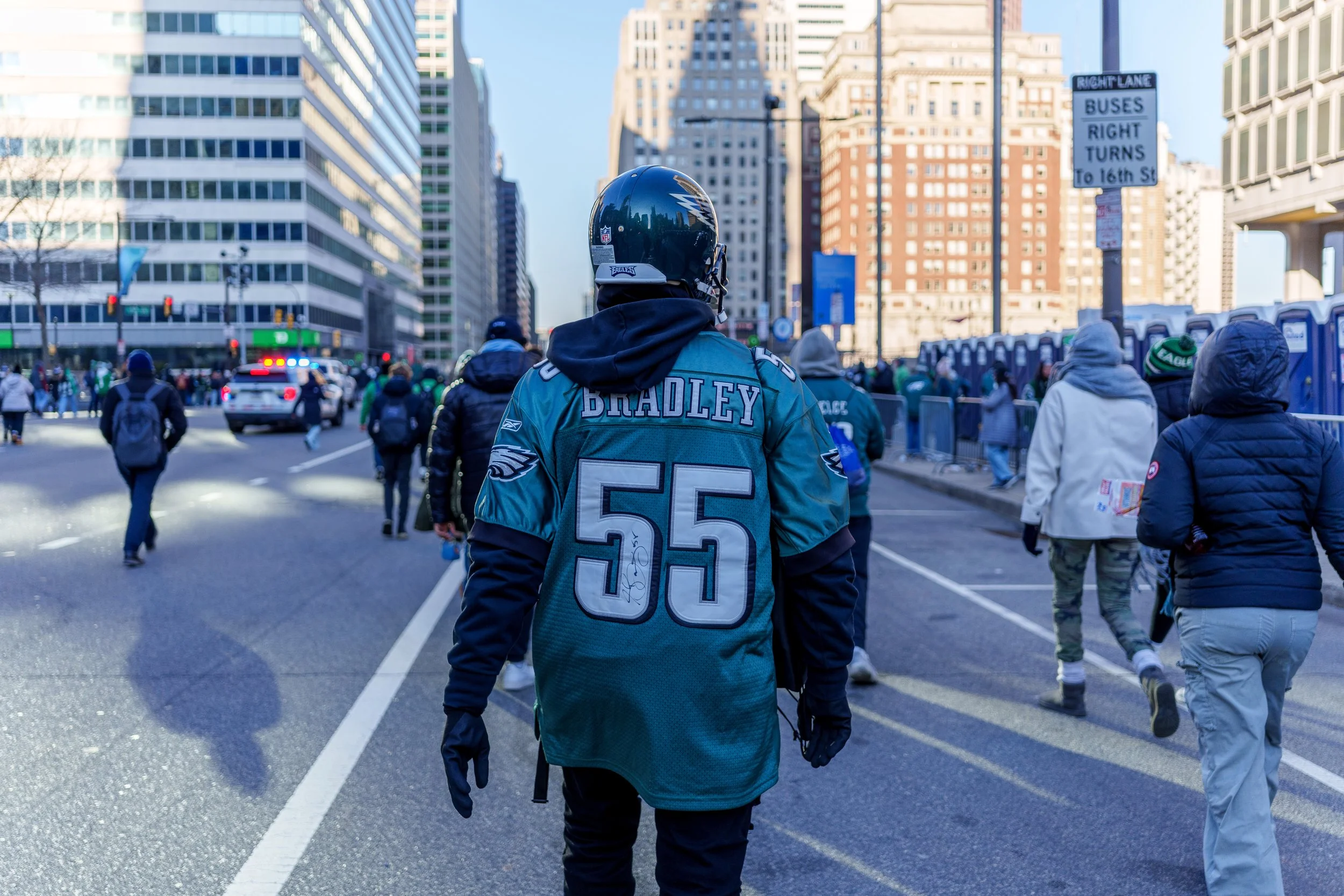 Fan in a Bradley jersey walking down a closed Broad Street toward the crowd