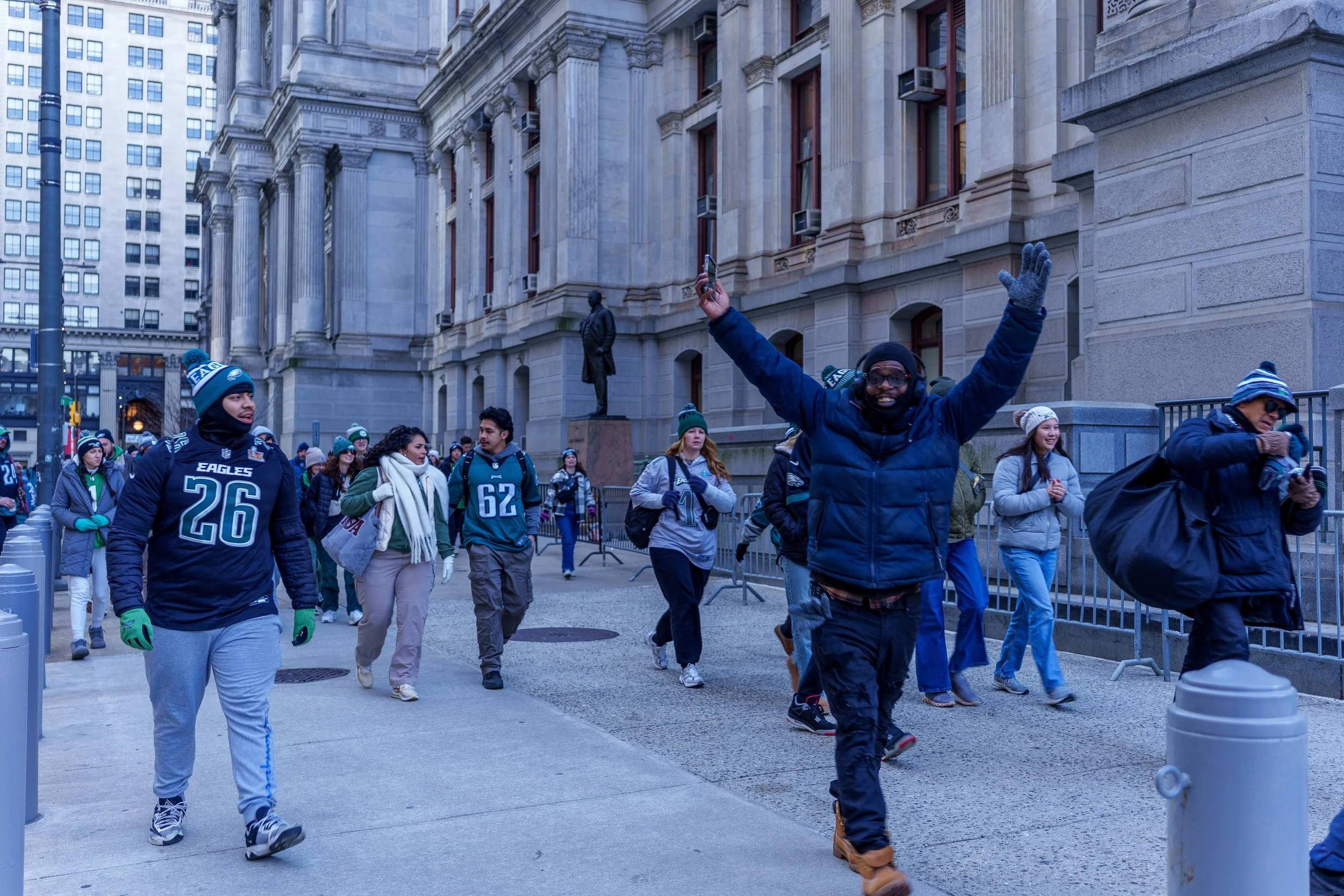 Fan celebrating with arms raised on the parade route