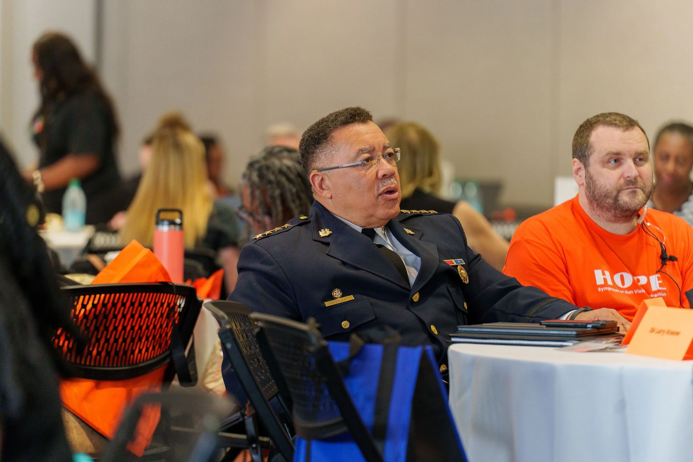A police partner seated with attendees at a table