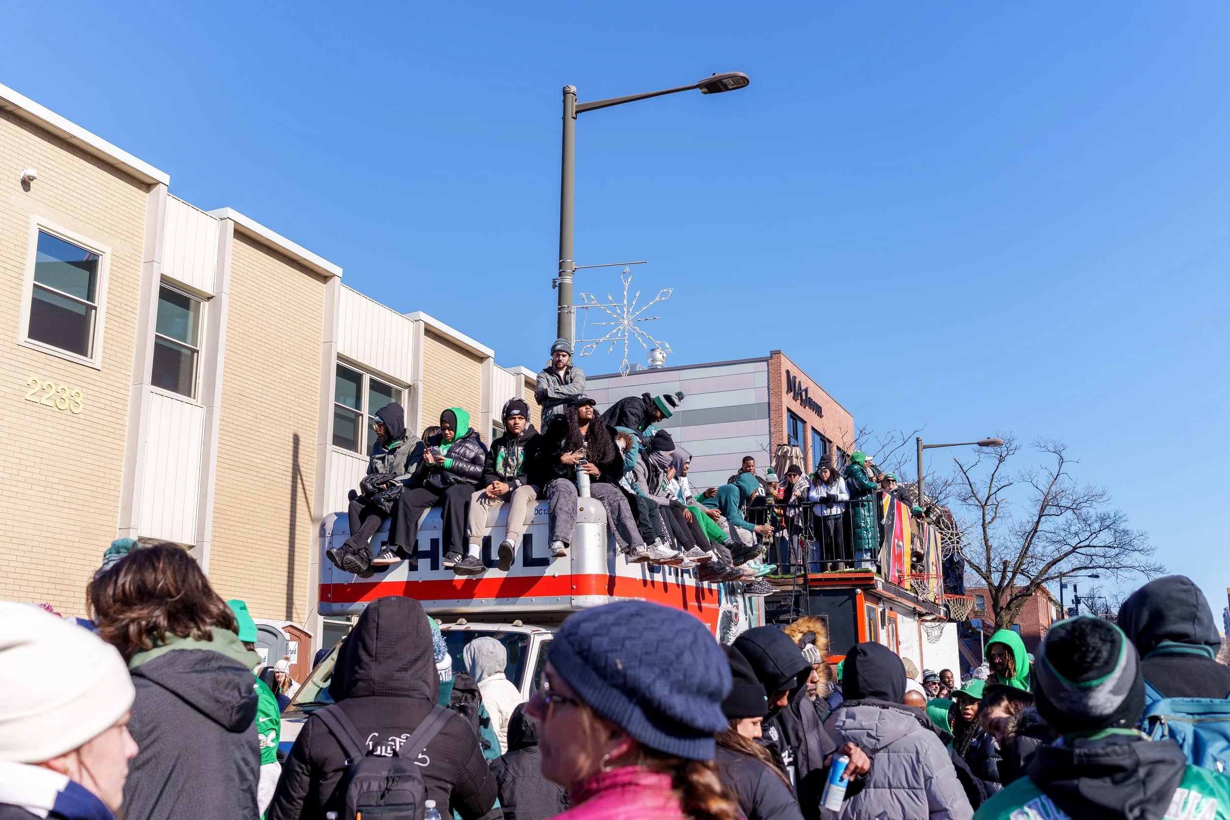 Fans watching from the roof of a vehicle in a neighborhood street
