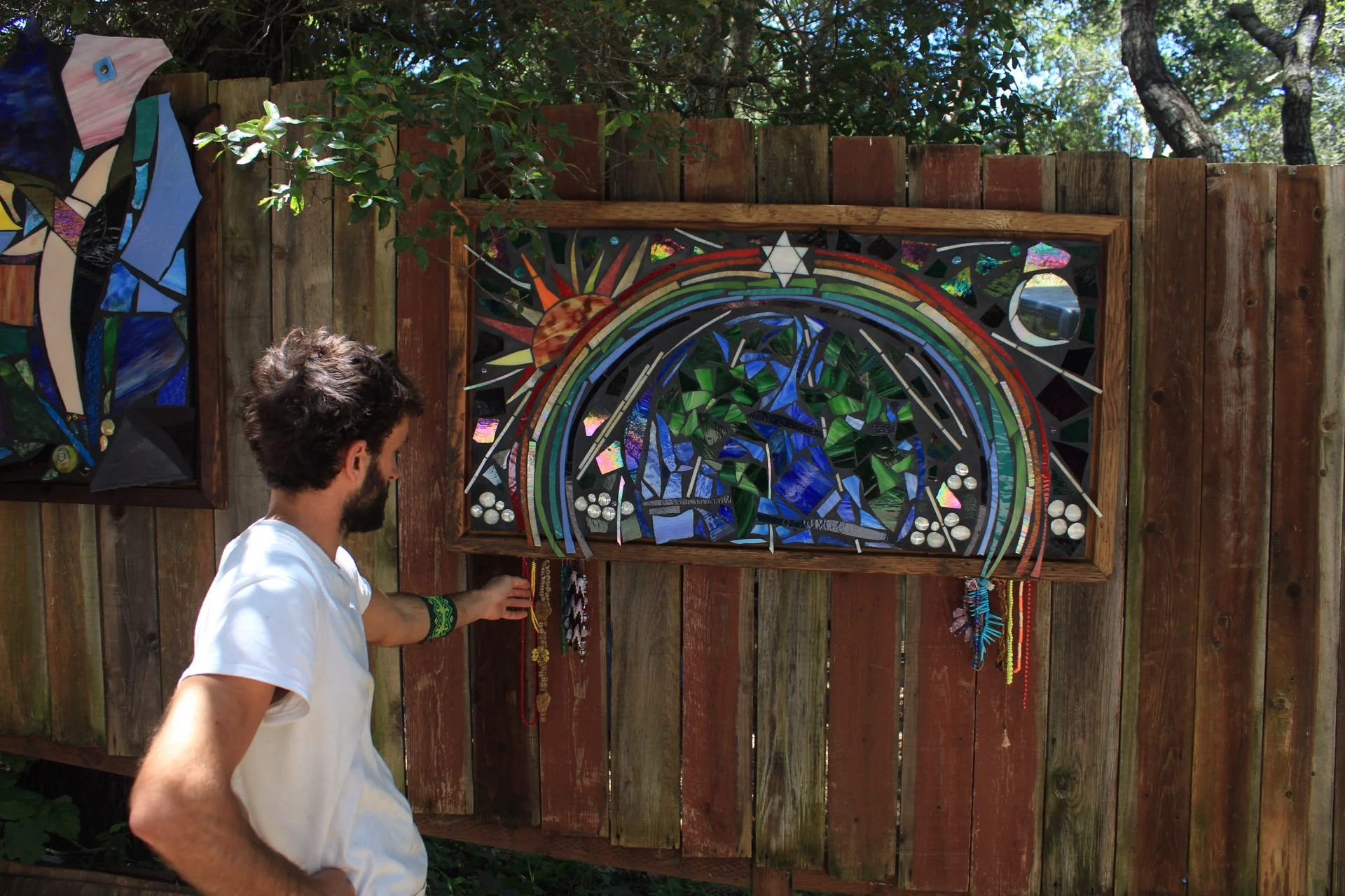 Miles Mathews examining rainbow cosmic mosaic outdoors