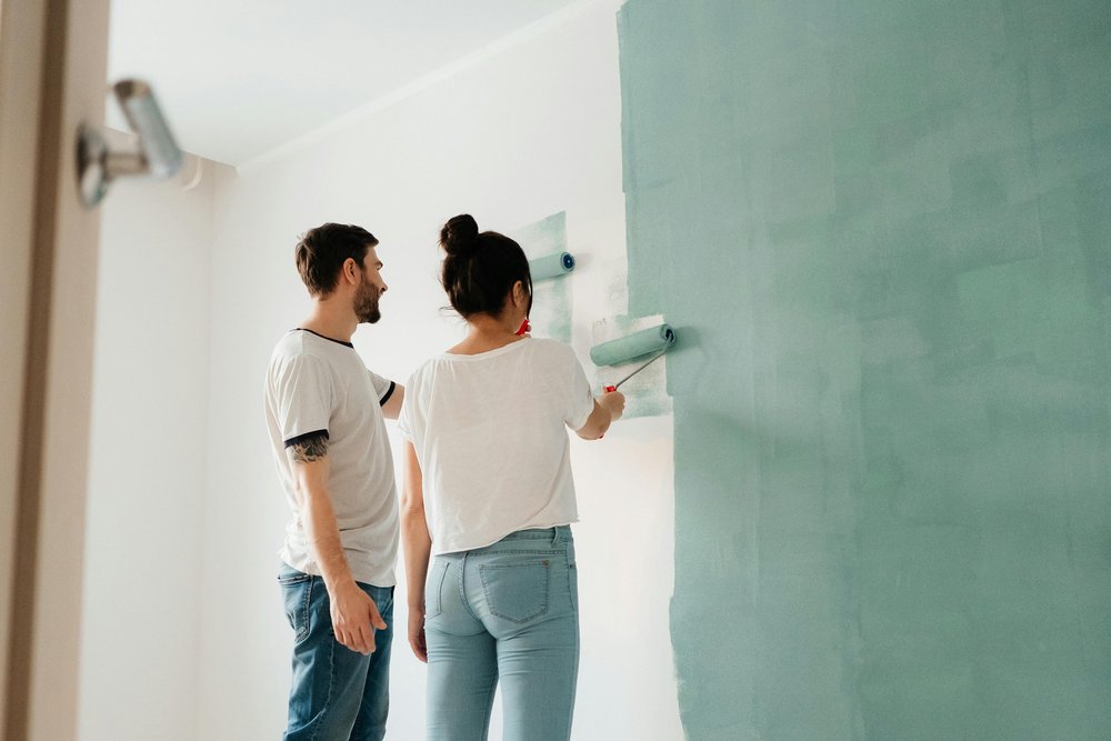 Couple painting the walls of their home during a renovation