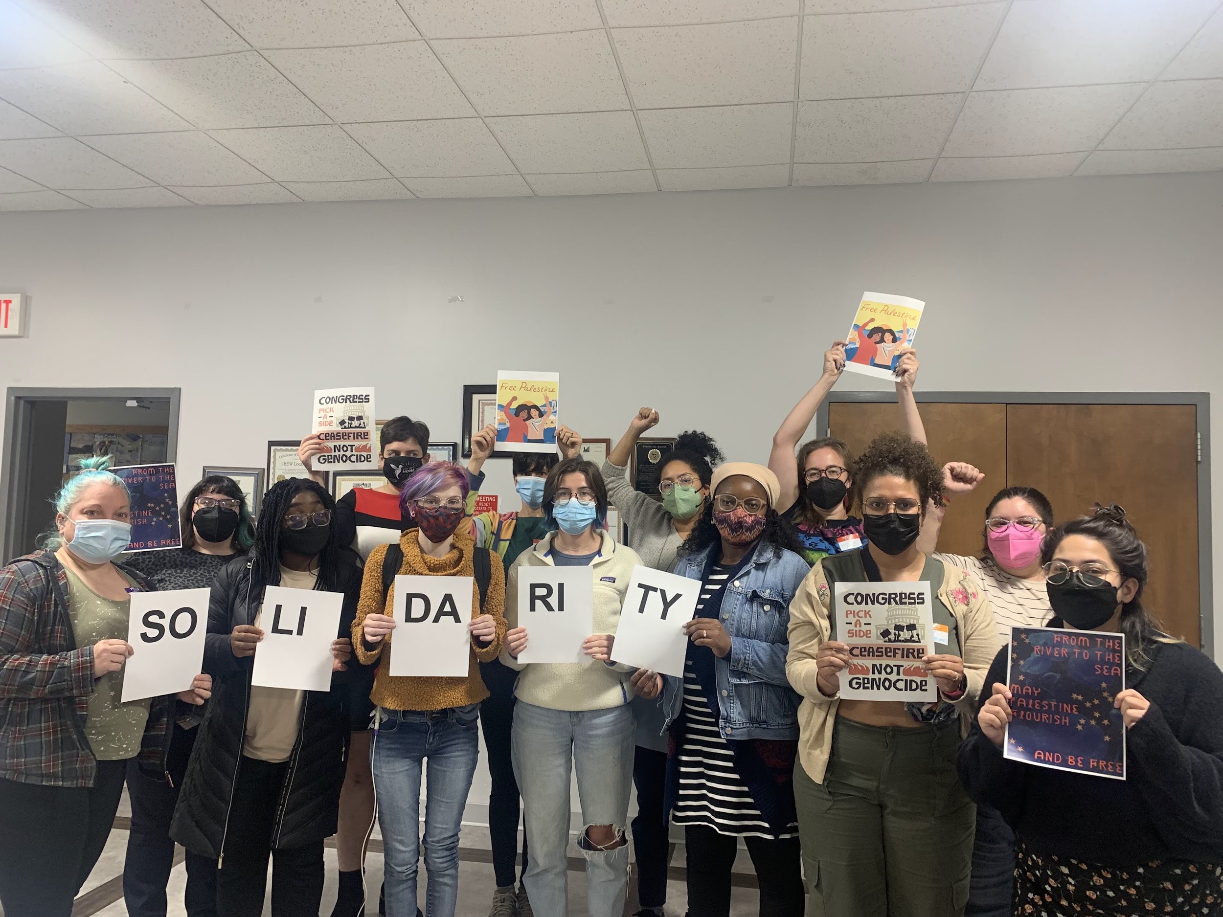 Members holding cards that collectively spell Solidarity