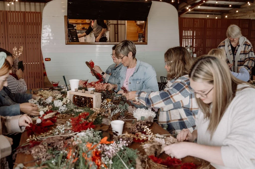 Guests crafting wreaths together at a Strike a Posie public workshop