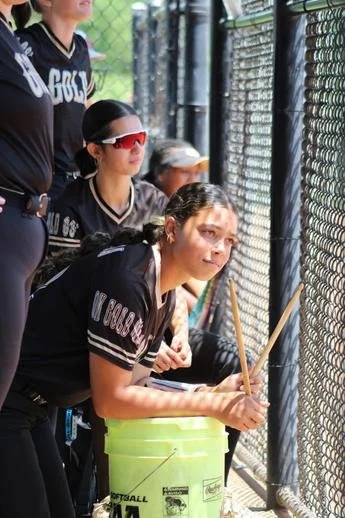 Supporting her teammates from the dugout.