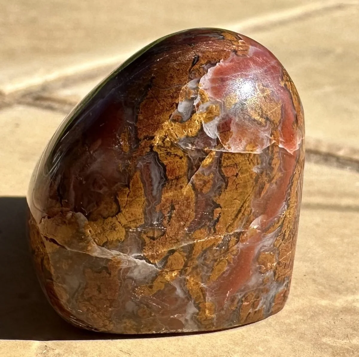 Jasper after polishing: a glossy freeform of red, gold and white