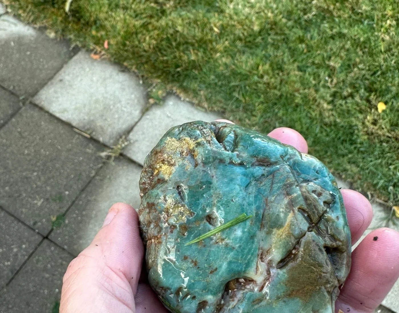 Close-up of a blue-green stone with rusty red seams
