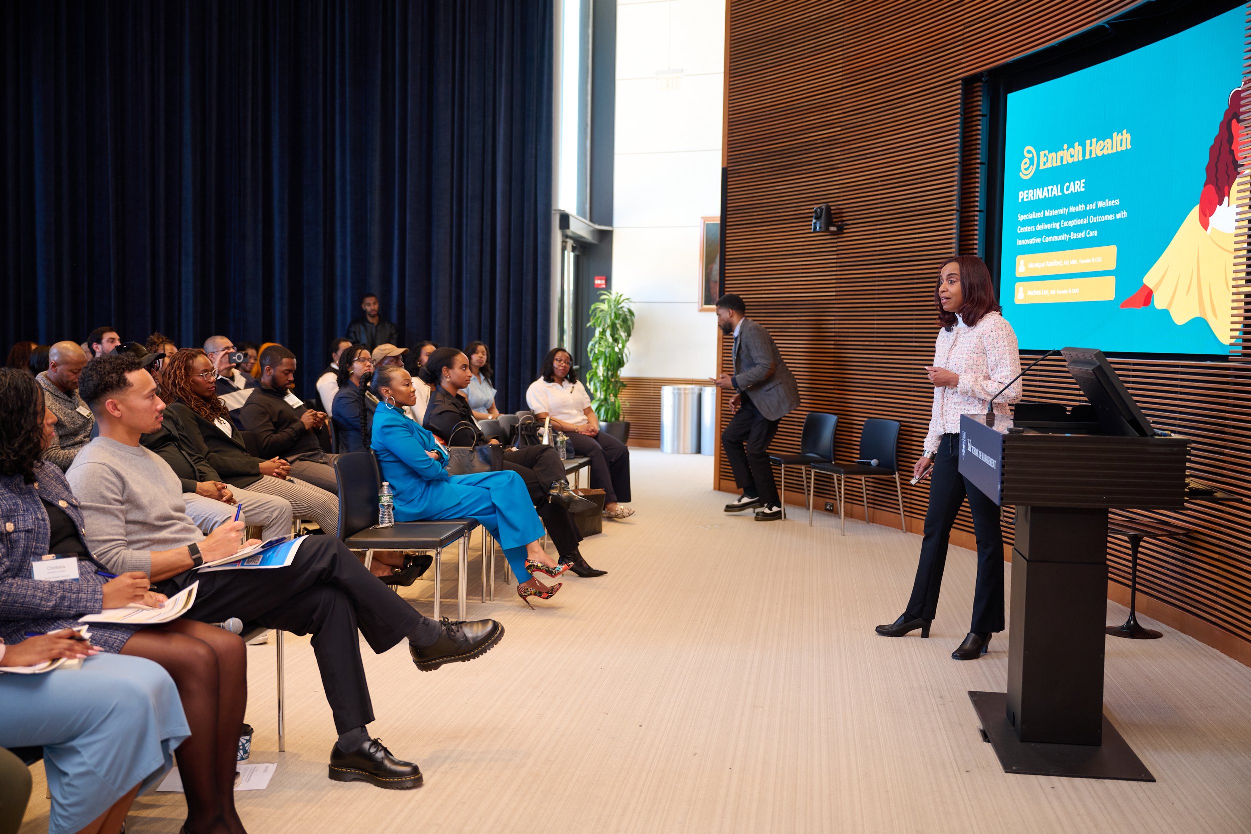 Attendees watching a summit presentation