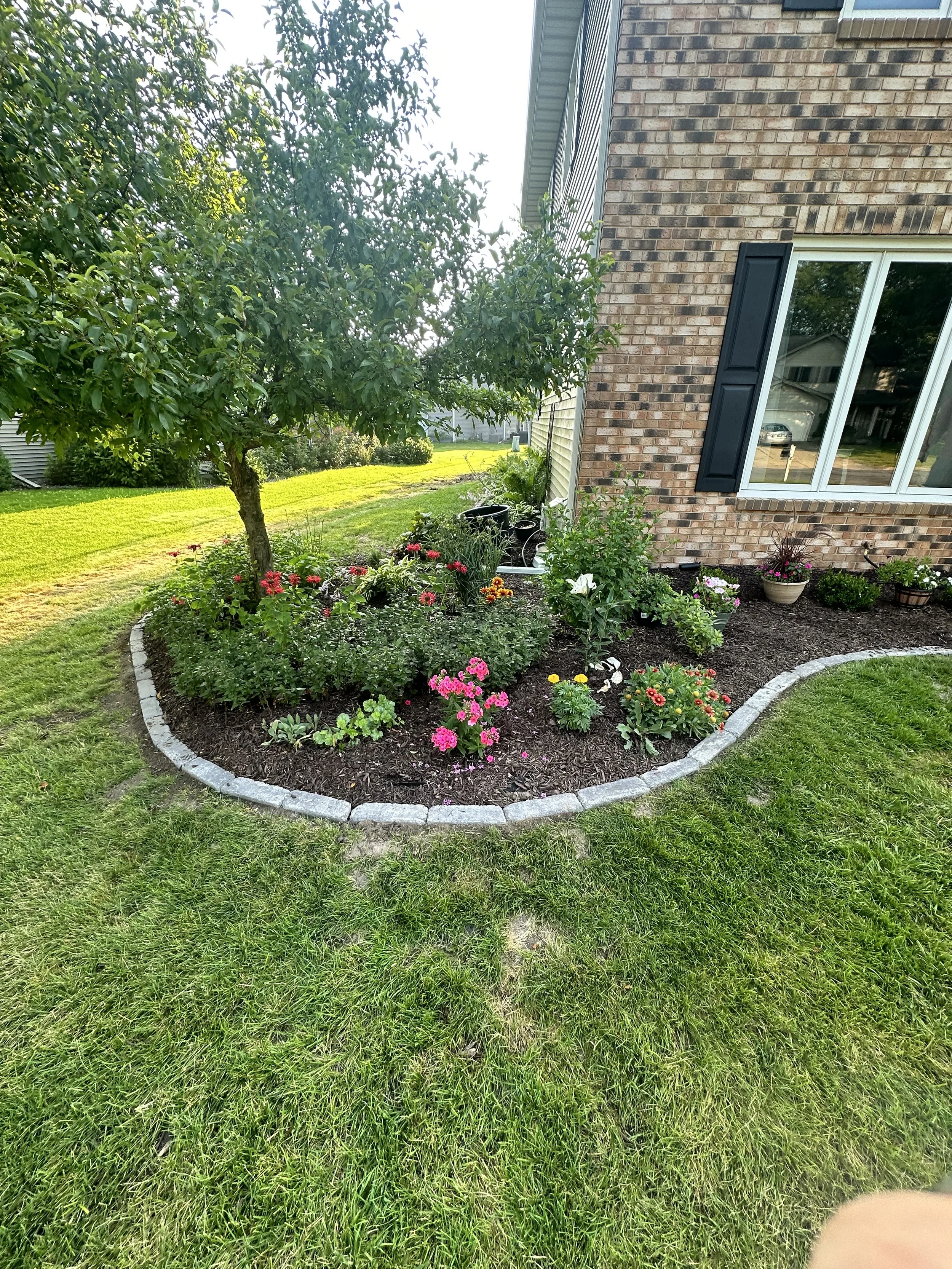 Curved stone garden edging installation in Wexford Village, Madison WI by YD Exterior Visions
