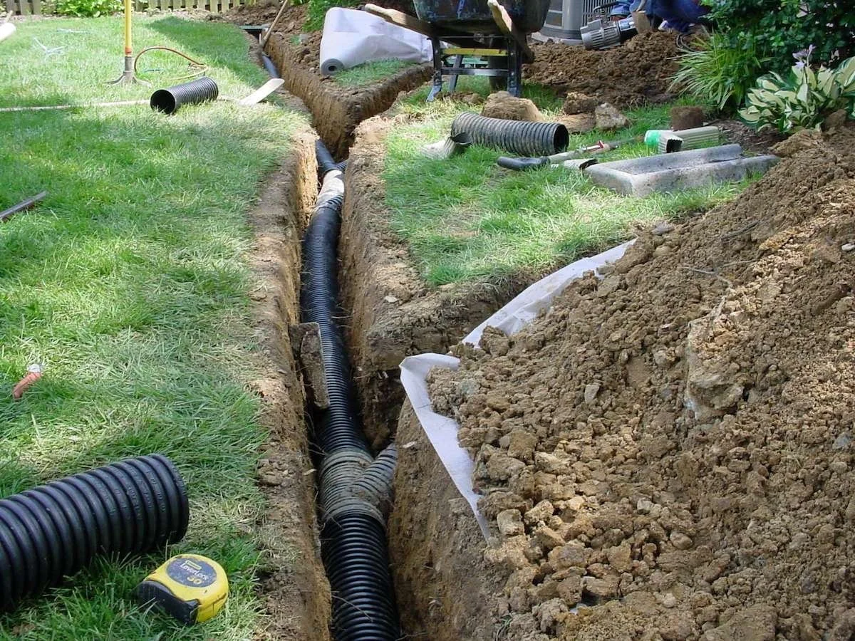 Downspout drainage line buried underground and routed away from the house