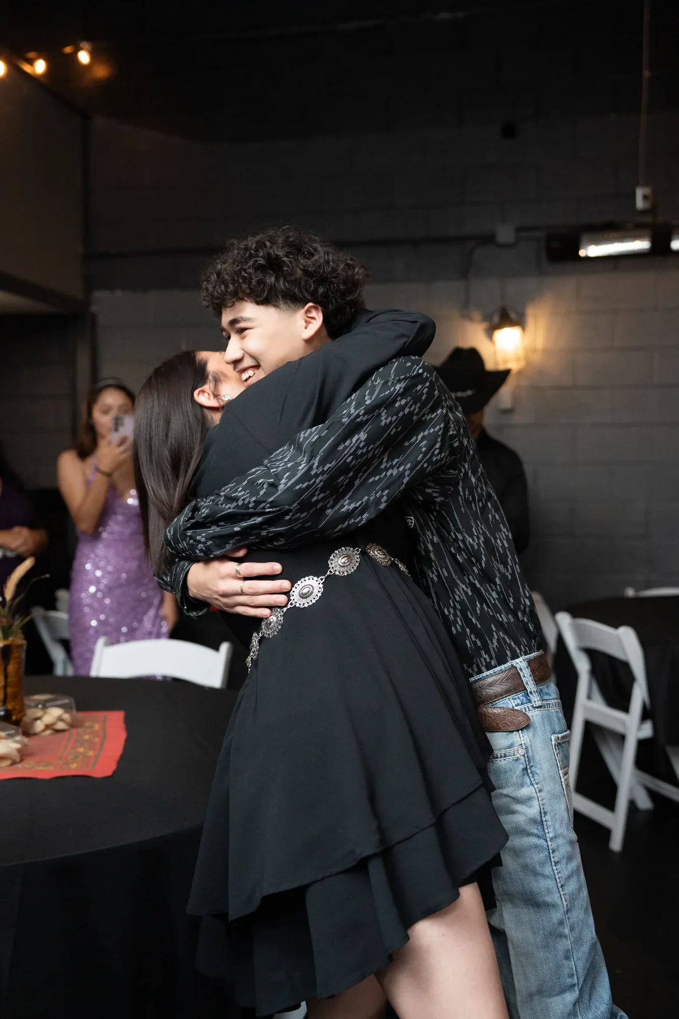 Un quinceañero abraza a su mamá durante su baile en la celebración de sus quince años