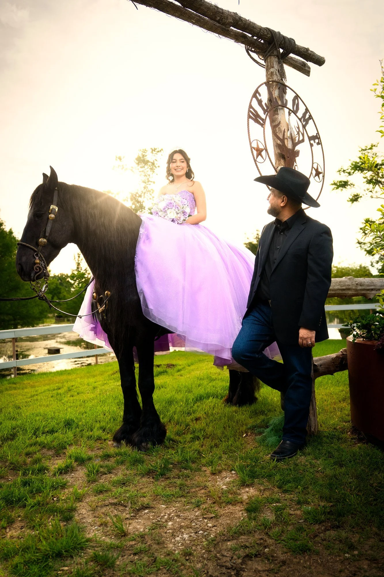 Quinceañera in a lavender gown beside a black horse