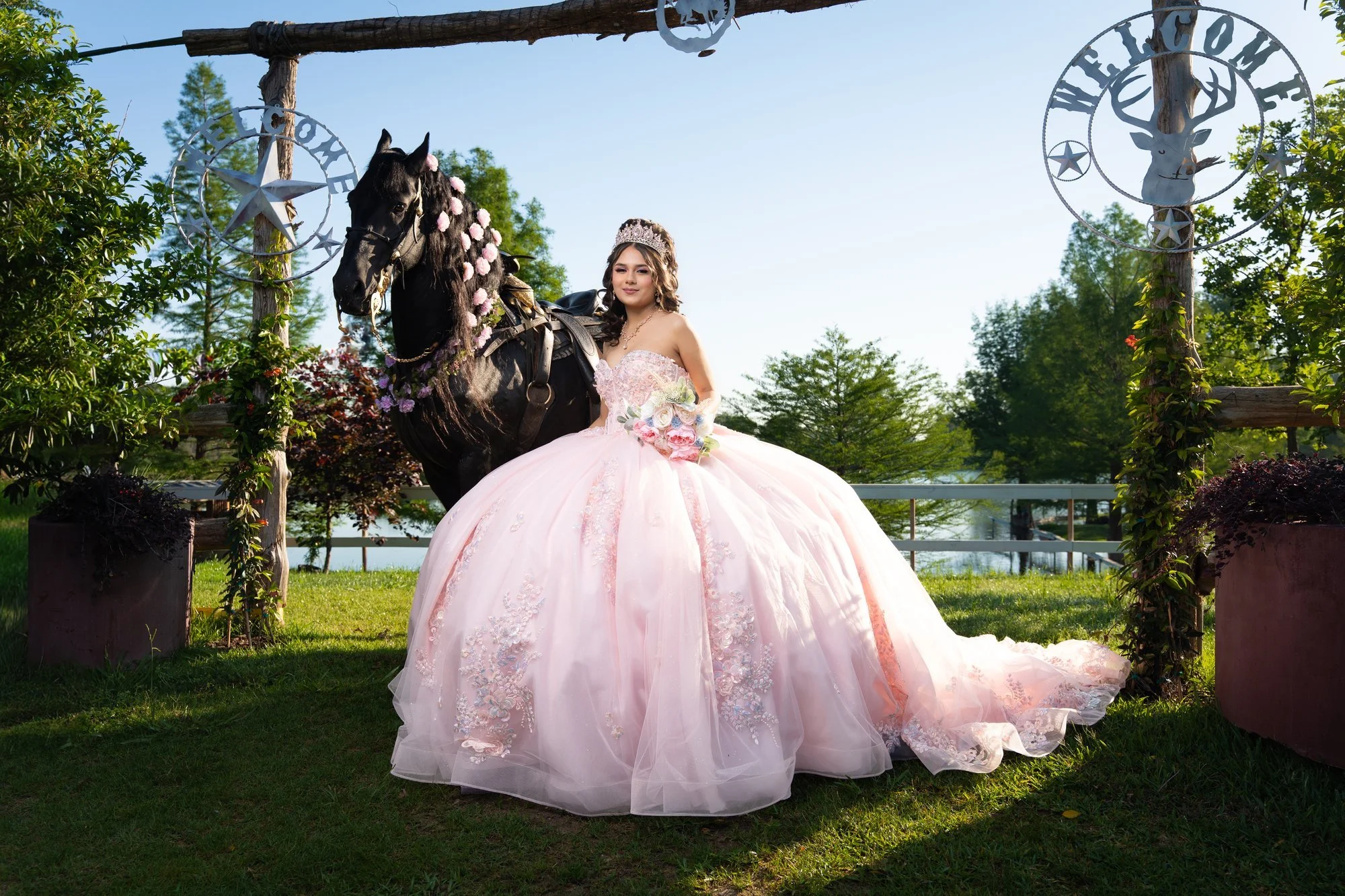 Quinceañera in a pink gown beside a black horse at a Dallas–Fort Worth ranch
