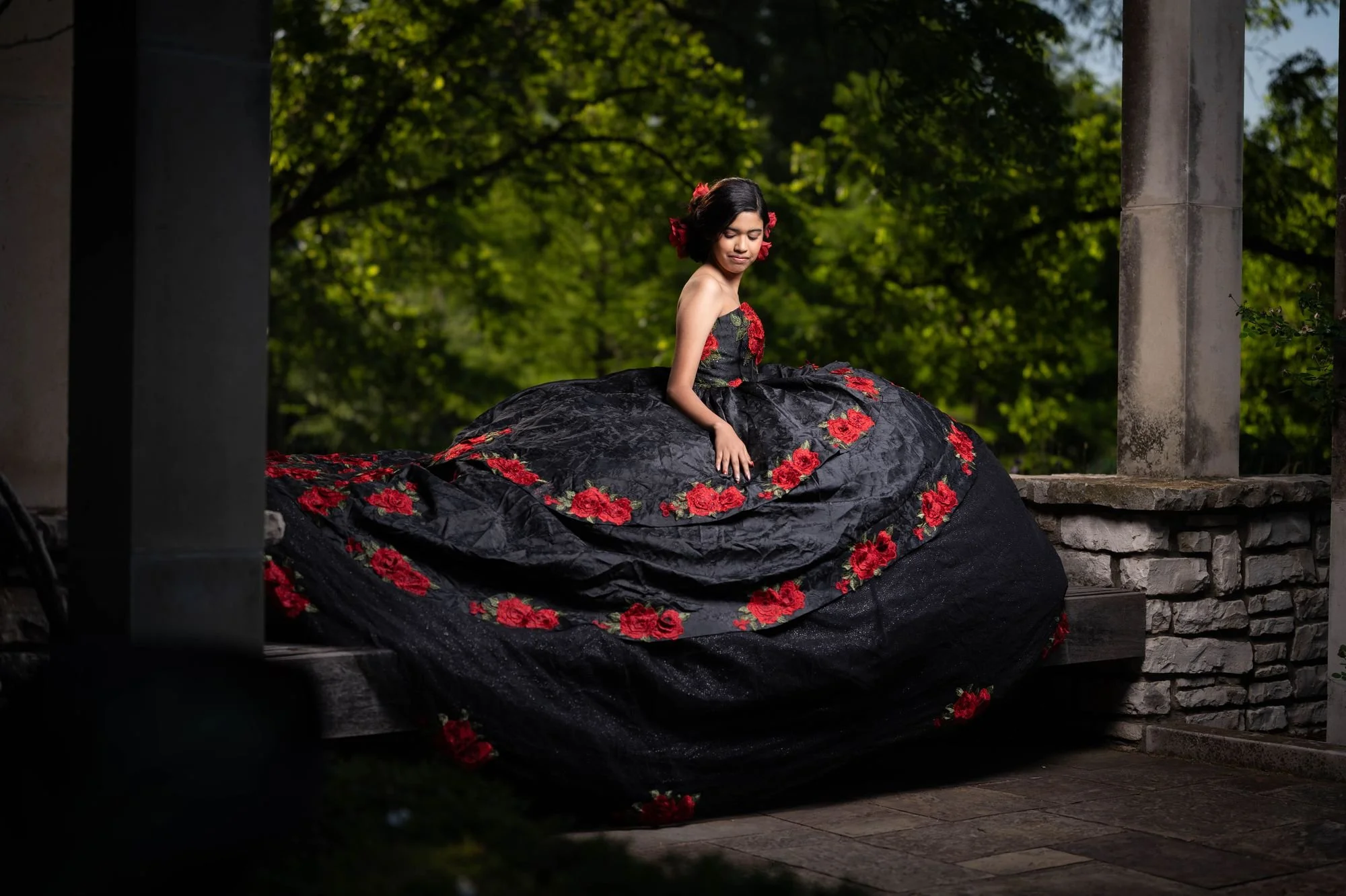 Quinceañera con vestido negro y bordado de rosas rojas para una sesión charro folklórico