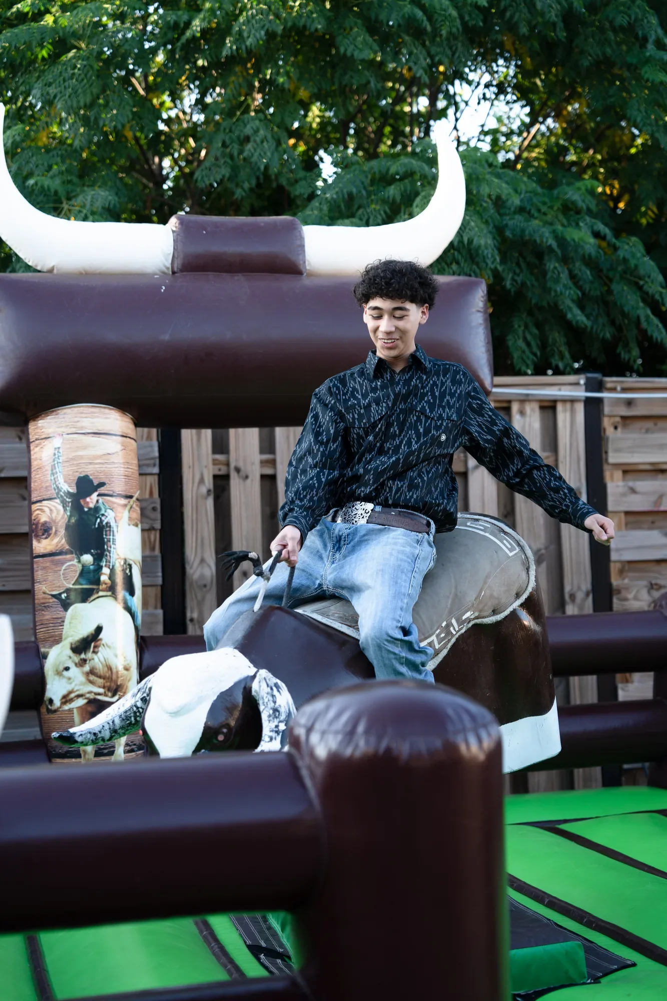 Un quinceañero monta un toro mecánico en su fiesta de quince años vaquera