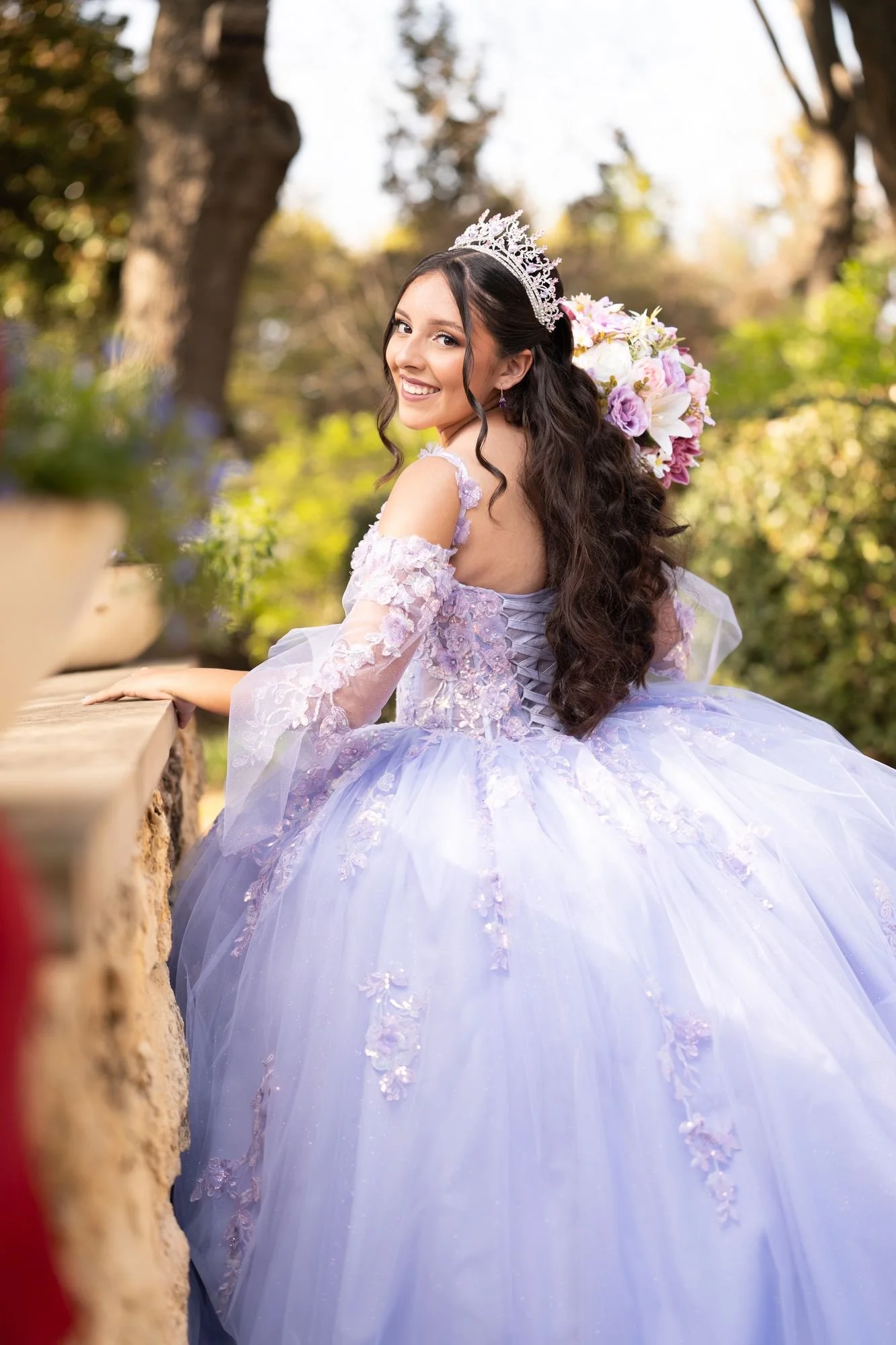 Quinceañera con vestido lila en un retrato de glam de estudio al aire libre