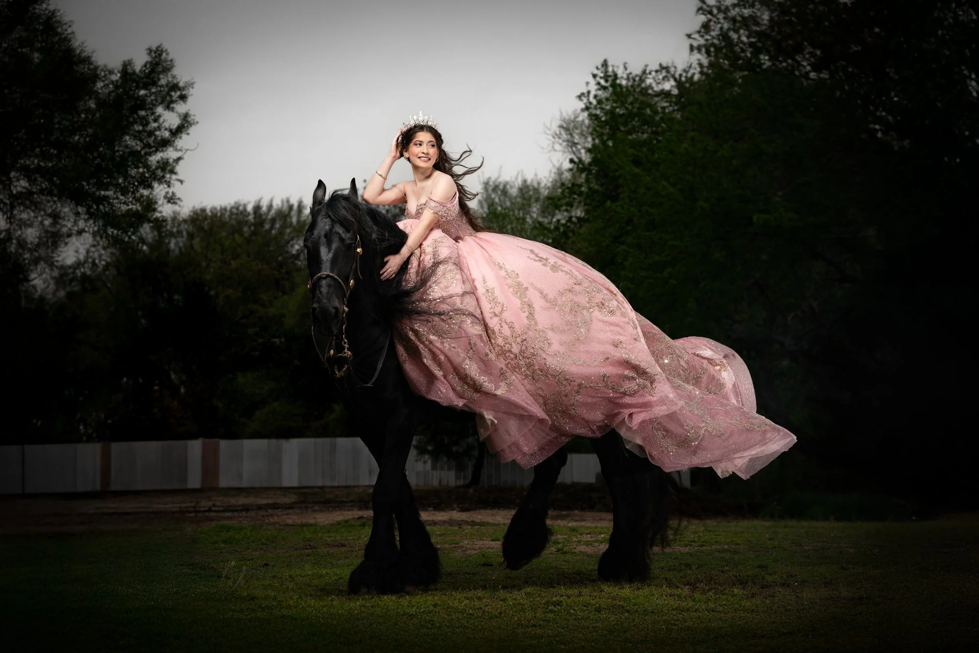 Quinceañera riding a black horse in a pink gown at a Dallas–Fort Worth ranch