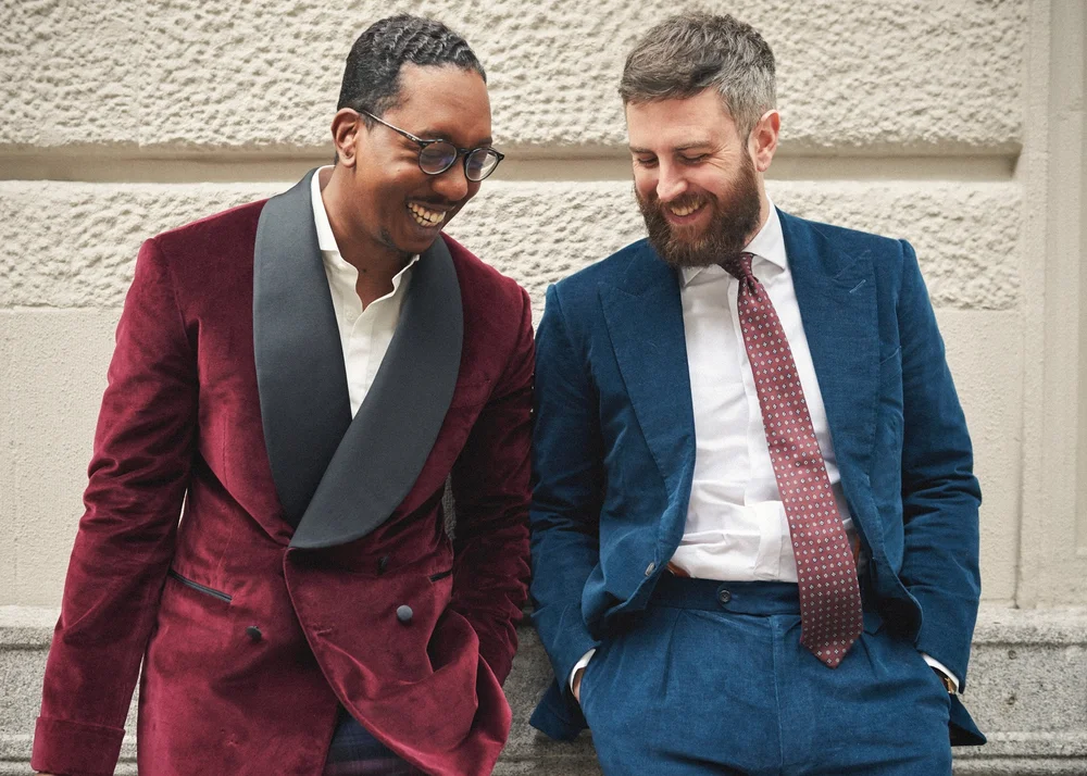 Two men in colorful suits laughing together during a New York street-style portrait session