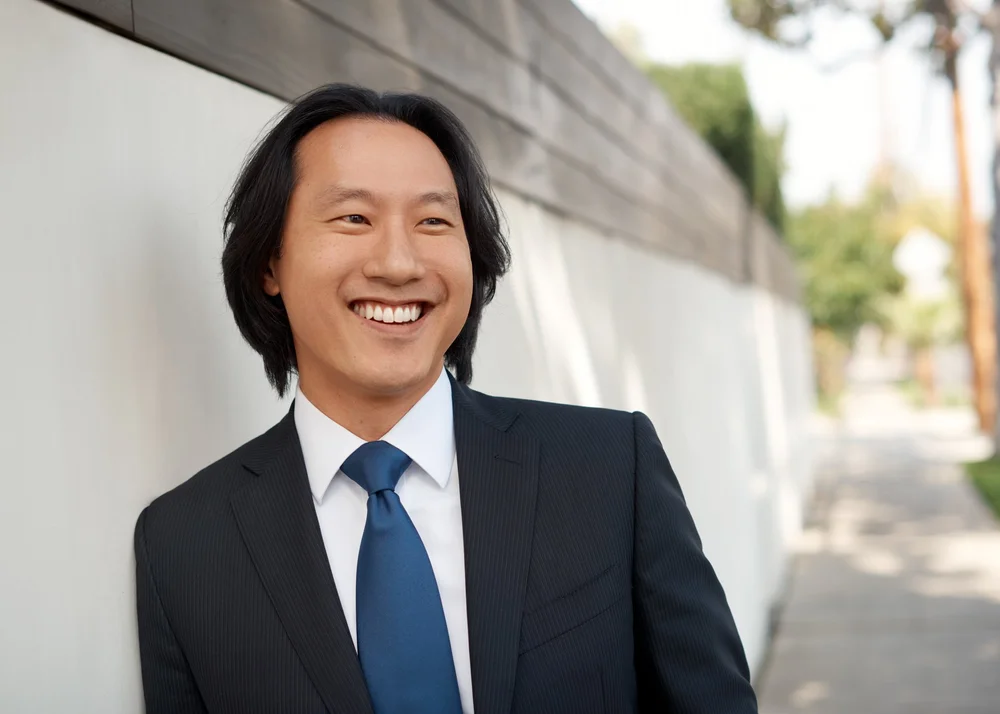 Smiling executive portrait of a man in a navy suit photographed outdoors in Los Angeles