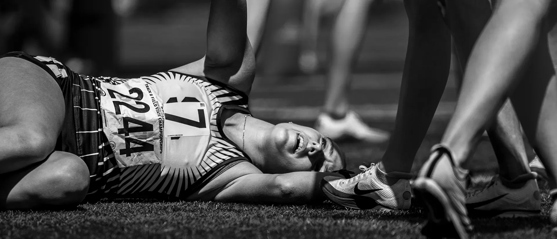 An exhausted runner alone on the infield after a distance race at the 2026 WIAA State Track Championships
