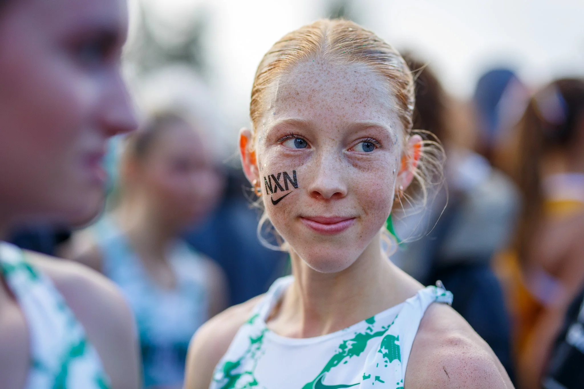 A focused high school runner leading the chase pack through the final kilometer at the 2025 Nike Cross Nationals (NXN).
