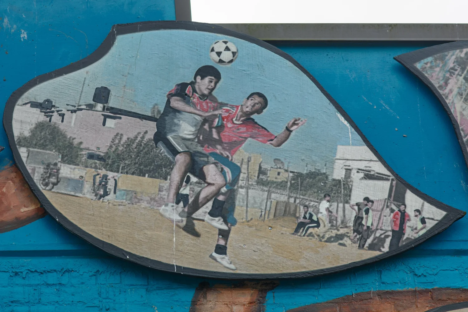 Leaf-shaped mural panel of two soccer players on a wall at North Point Plaza in Olympia