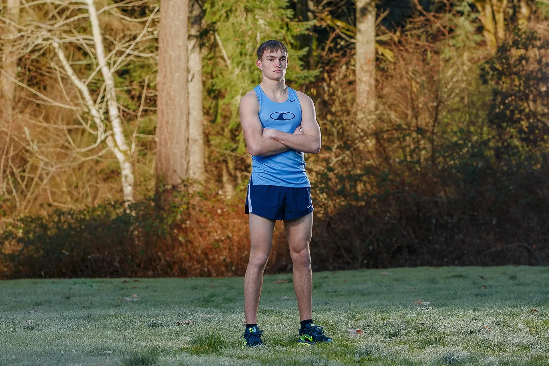 Max Dower standing portrait in Gig Harbor Tides singlet, forest backdrop