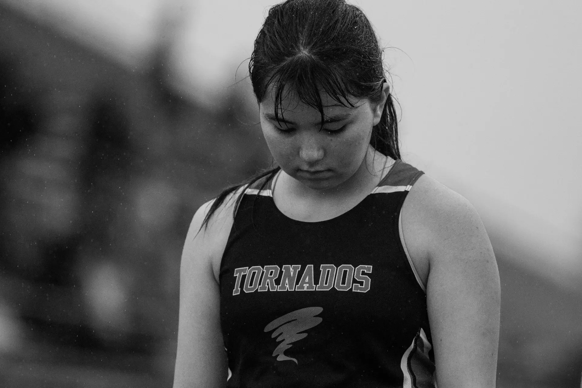 Atmospheric black and white portrait of a Yelm Tornados track athlete in a light drizzle.