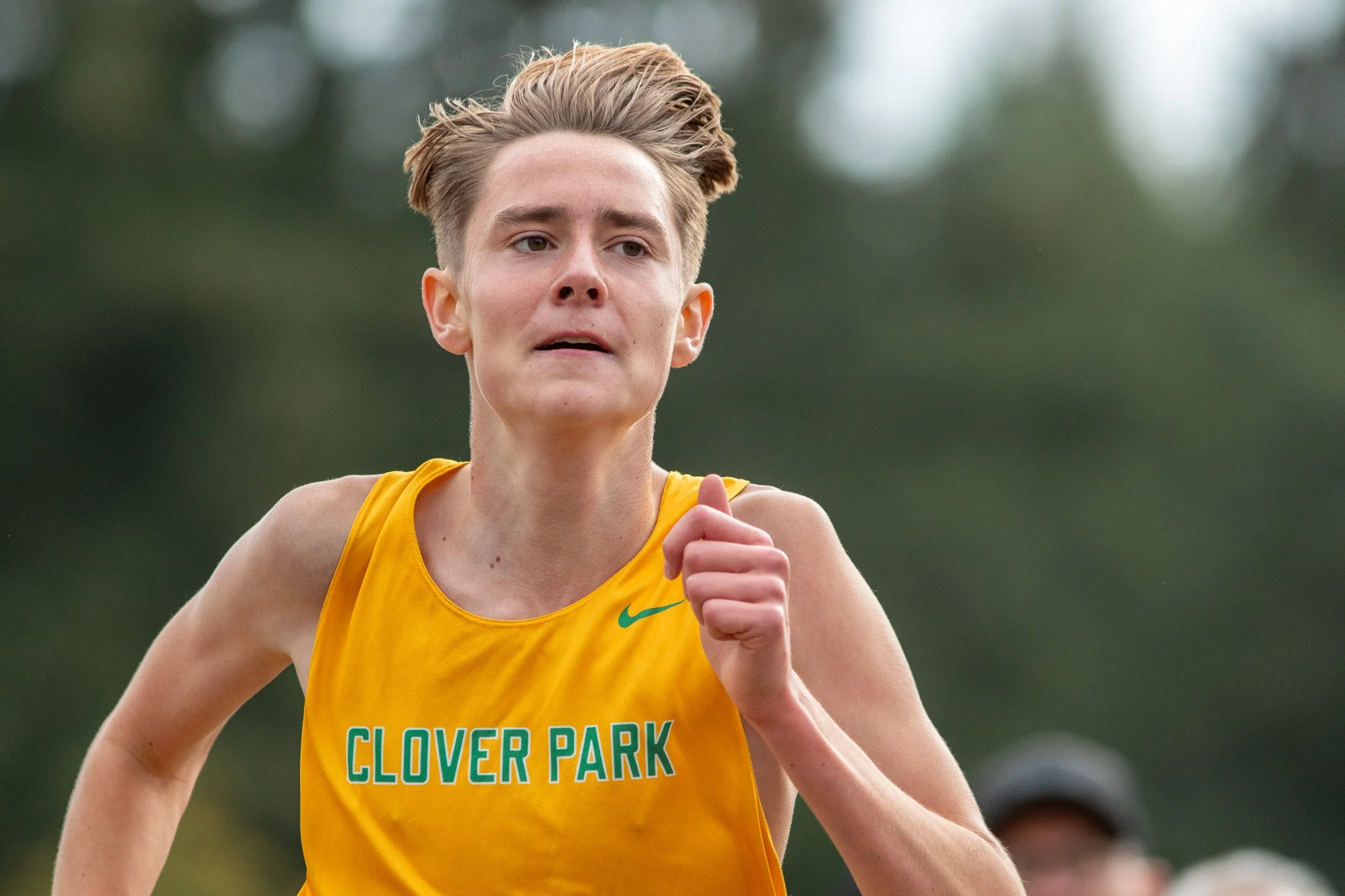 Boy in yellow Clover Park jersey running alone at the 2026 Olympia XC Classic.