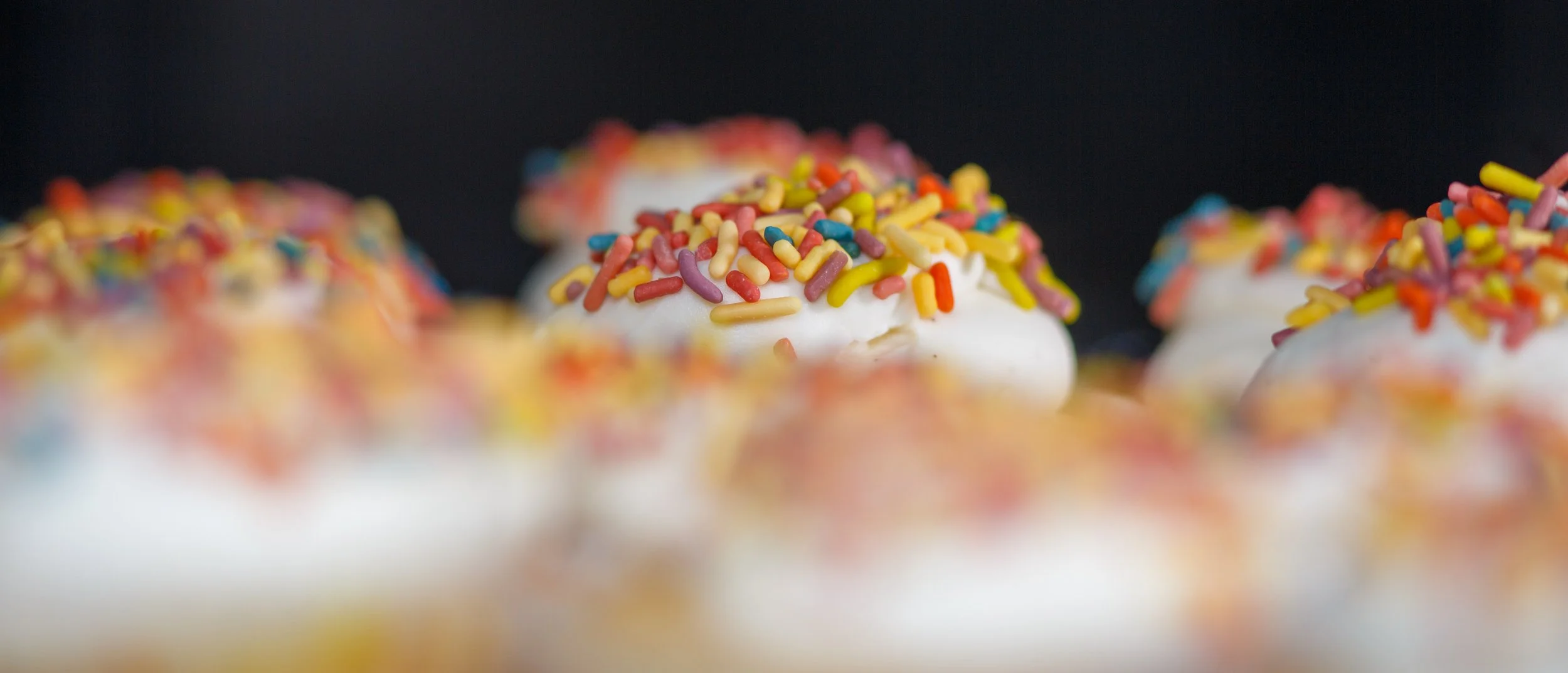 Macro of sprinkles on cupcakes in display case