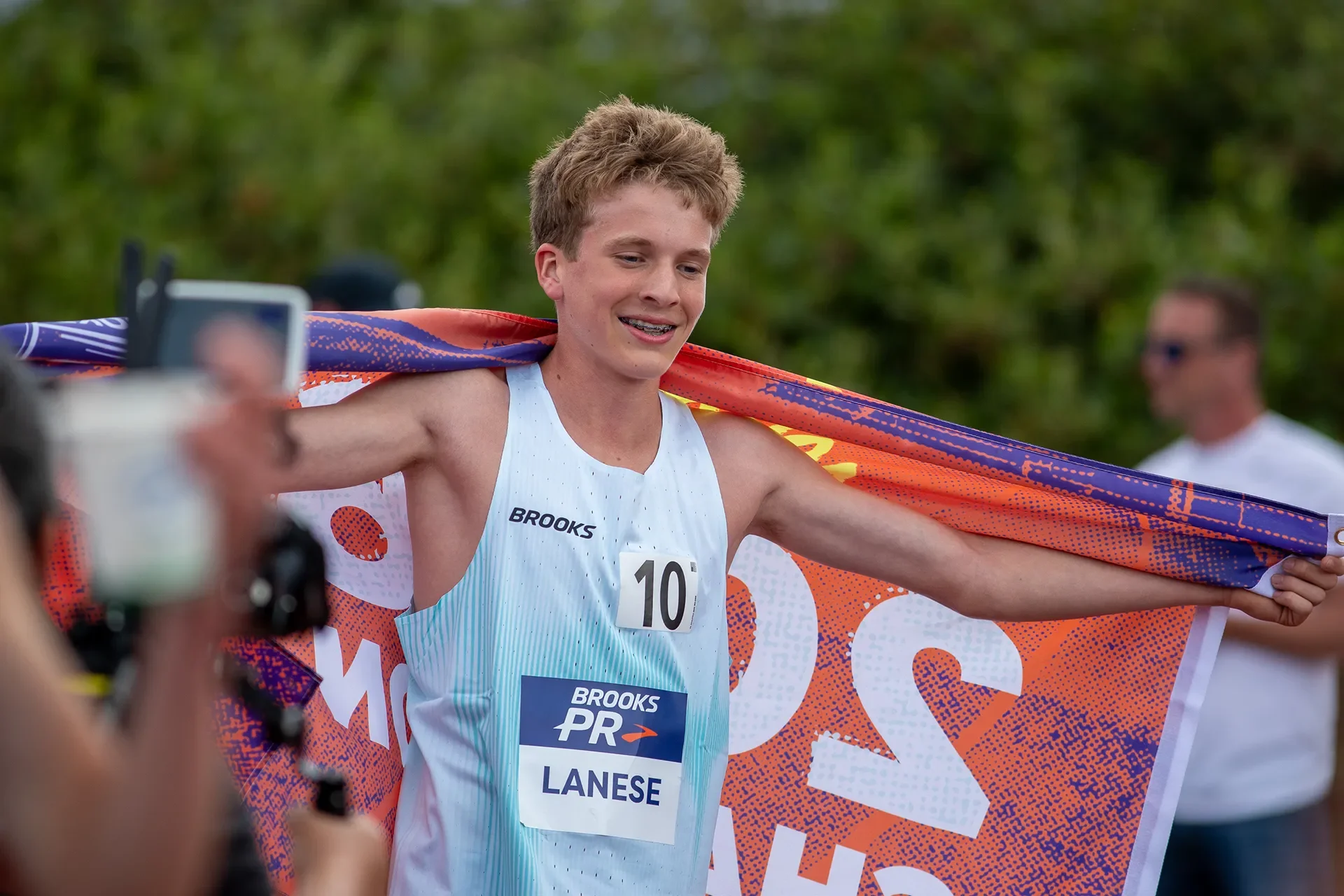 Quenton Lanese draped in the champion flag after winning the Boys Freshman Mile