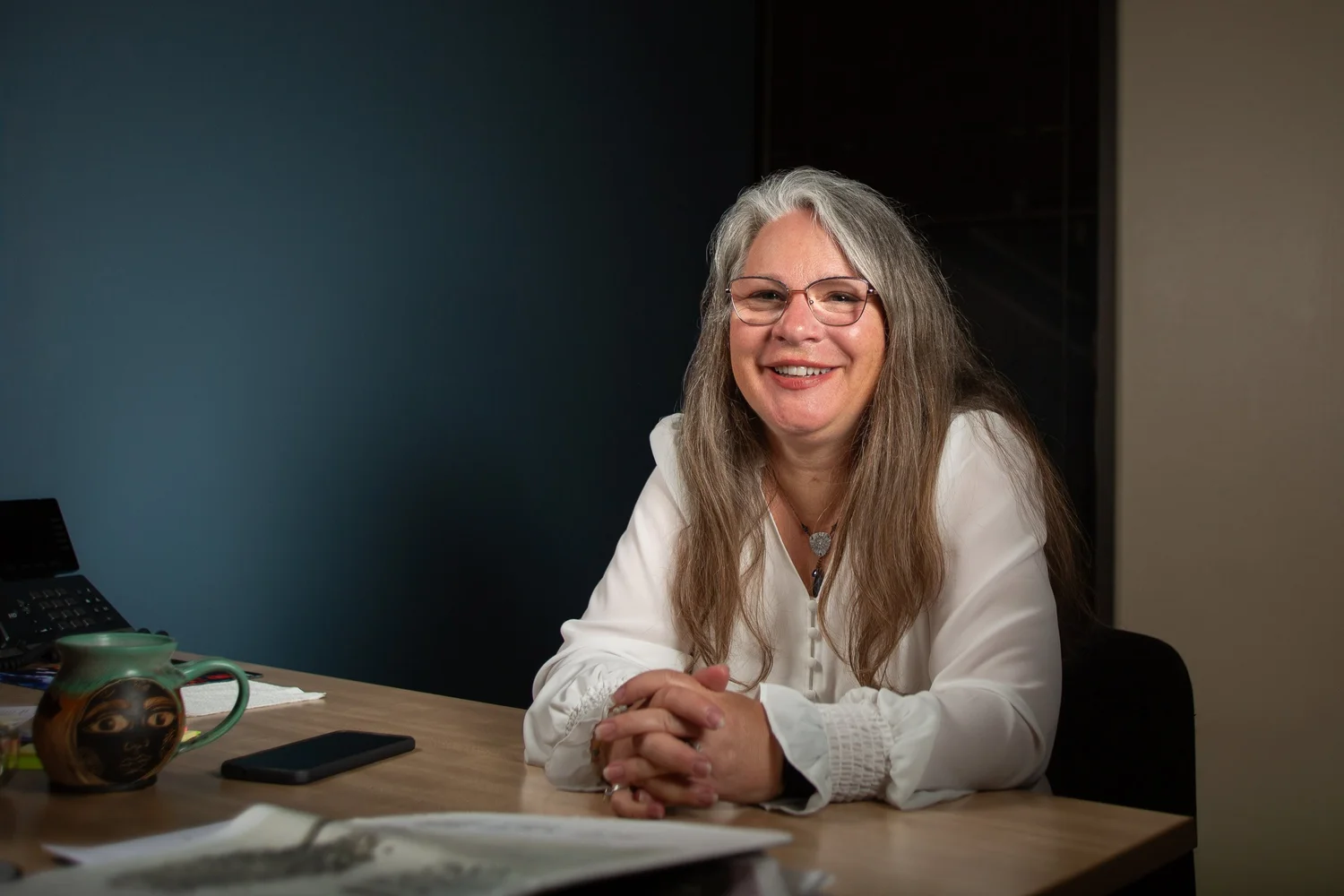 Shawn Harju seated at her desk in the Chrysalis Solutions office