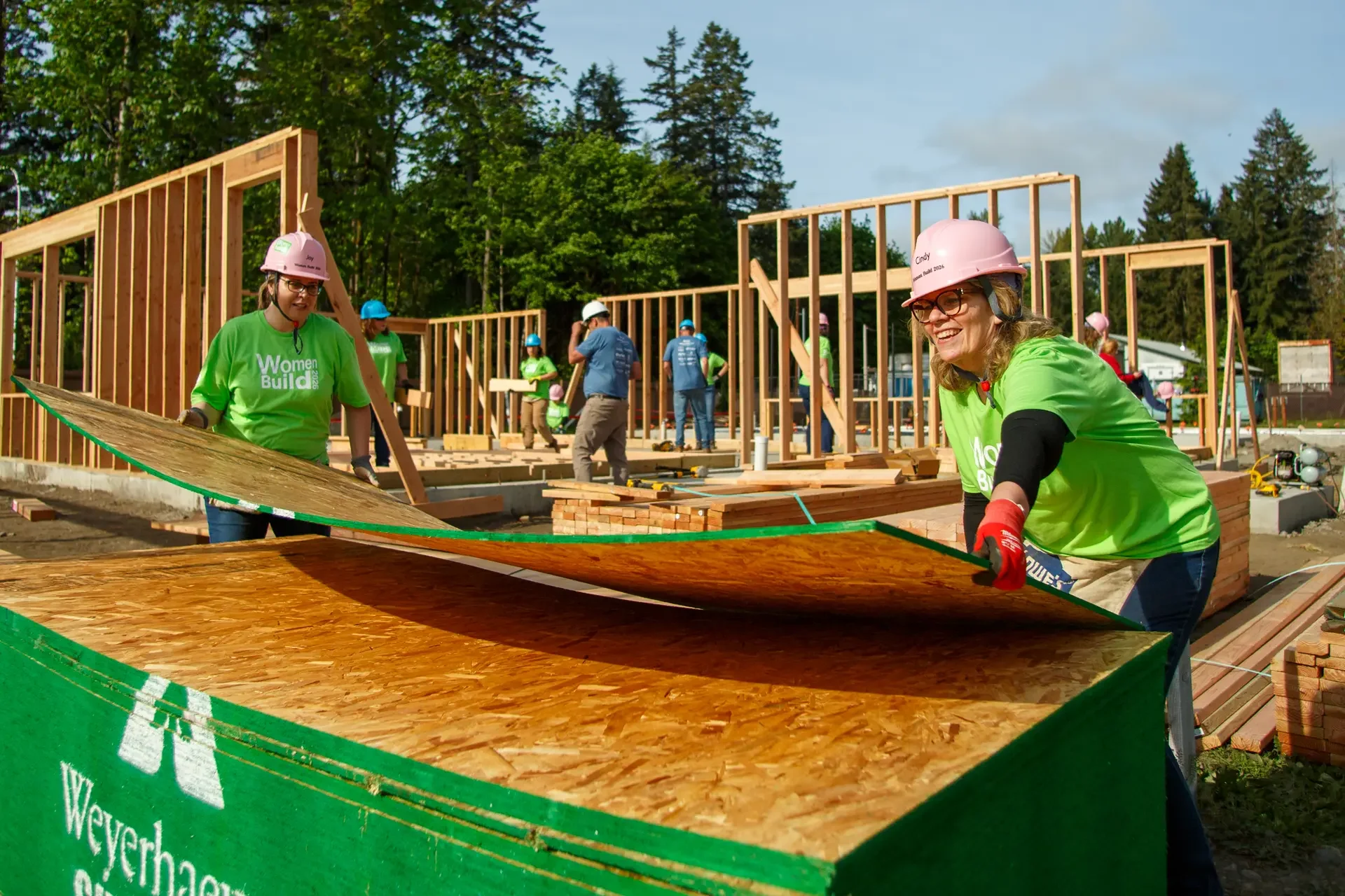 Volunteers lift and carry plywood sheeting during the South Puget Sound Habitat for Humanity Women Build