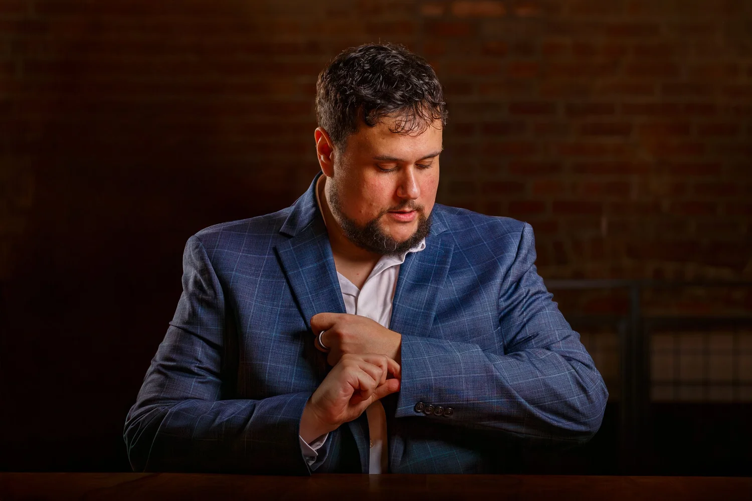 Headshot of Amir Yousef in a suit against a red brick wall