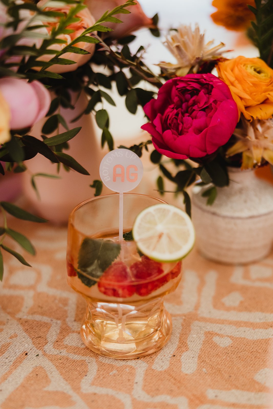 Citrus-garnished drink at a colorful table. Dave Stremikis Photography, Copper Feather / WedPlan editorial.