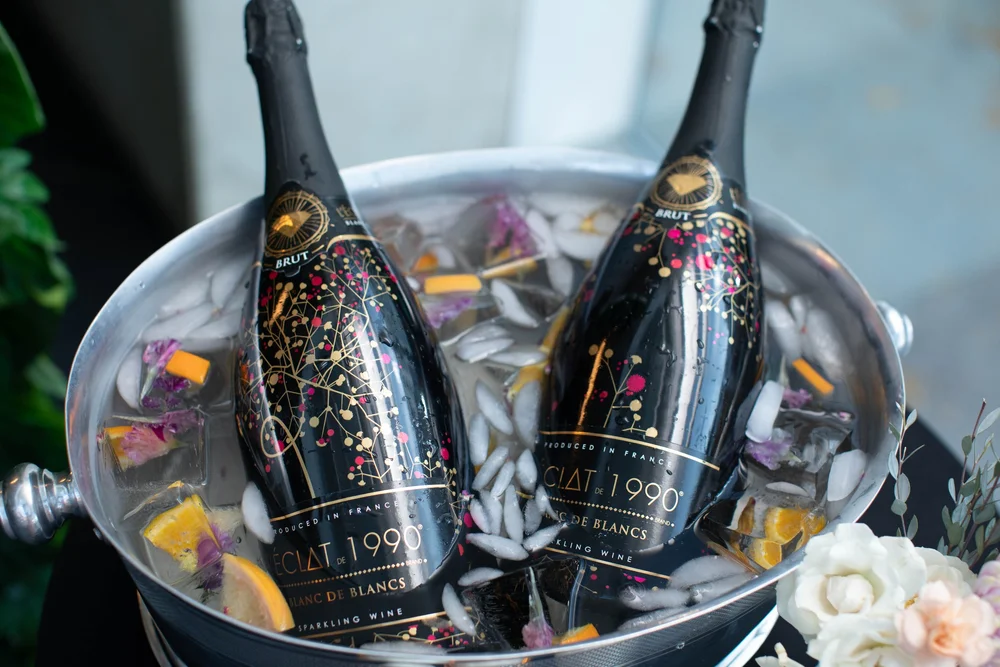 Sparkling wine chilled among citrus and flower-filled ice. Photograph by Kuffel Photography.