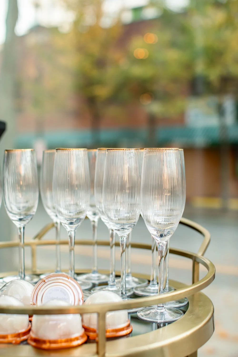 Polished glassware arranged on a gold drinks trolley.