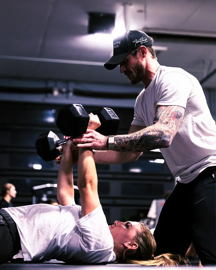 Coach spotting a client on dumbbell press