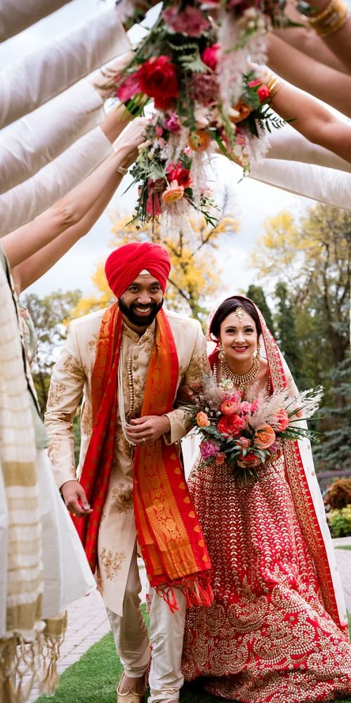 Indian wedding portrait — couple running outdoors under bouquets, laughing