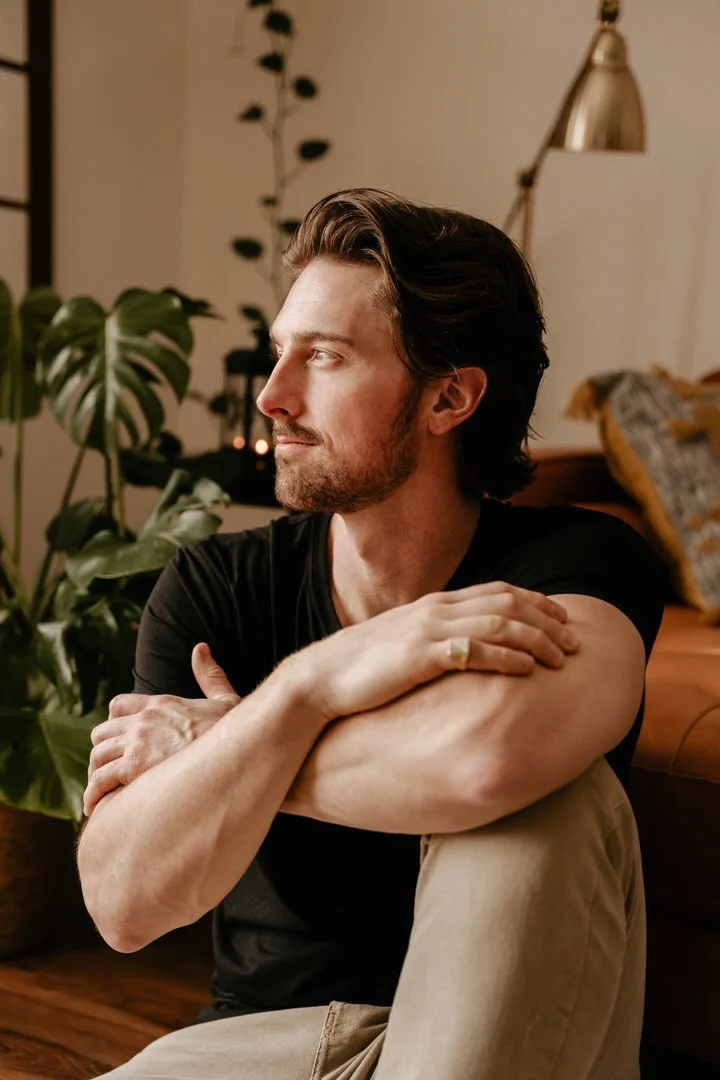 Mark Eadie, Winnipeg photographer, seated in window light at home