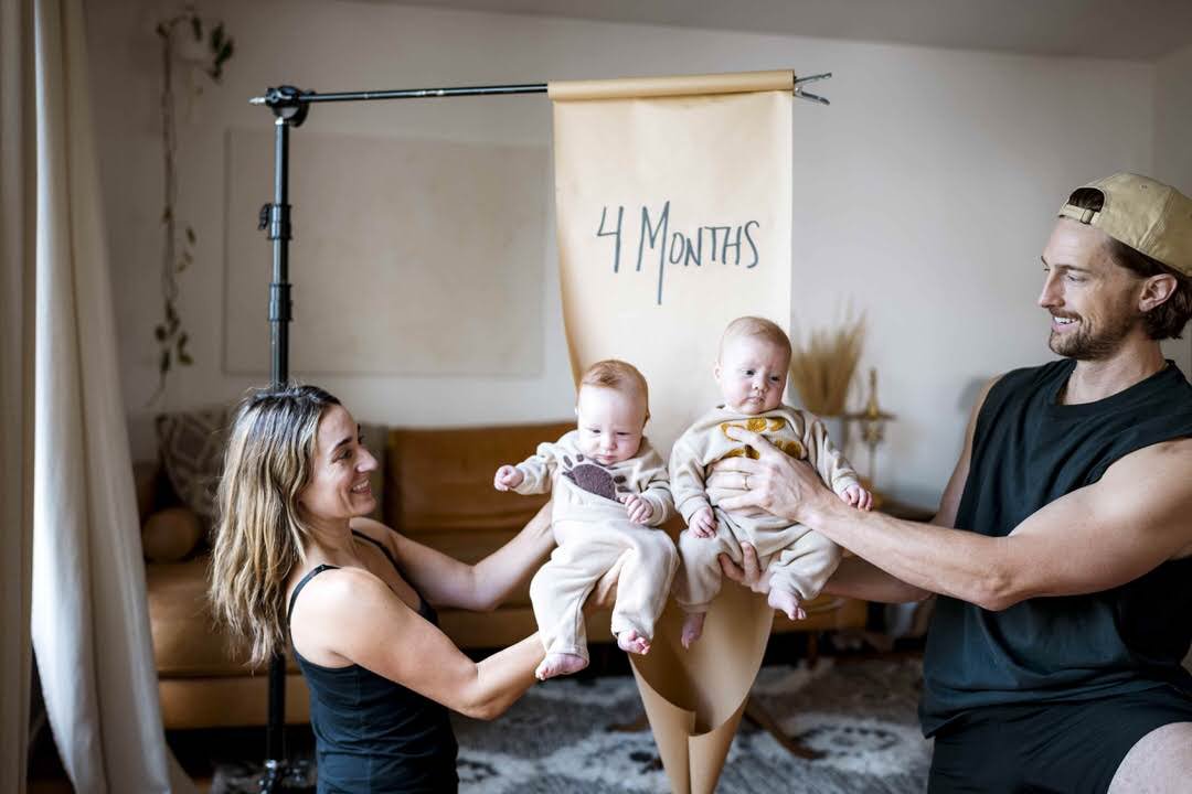 Mark and Anna photographing their twins' four-month milestone at home