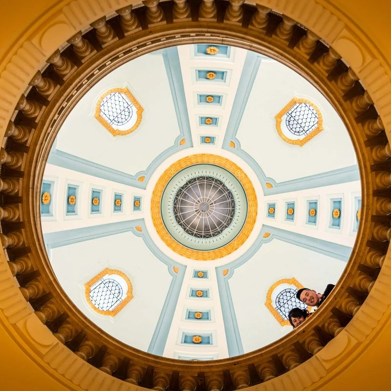 Creative indoor wedding portrait — couple framed through a circular opening in the floor