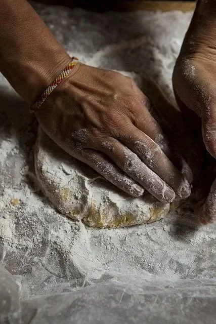 Floured hands pressing pinsa dough