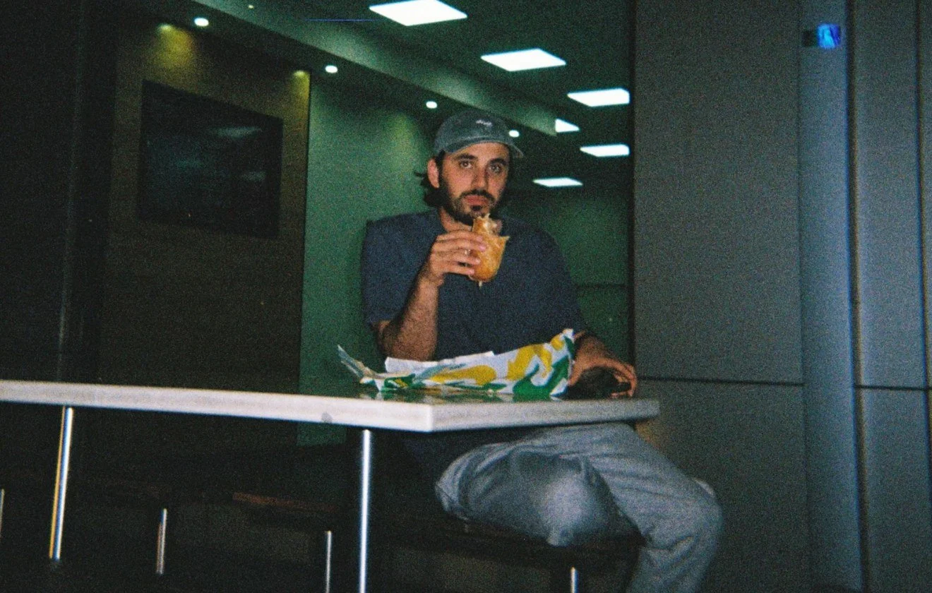 Marc Vecchio at a fast-food table at night, shot on film