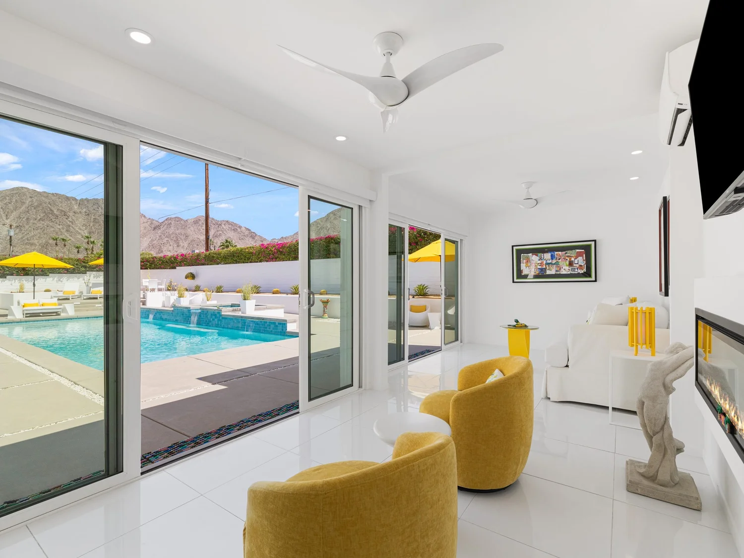 A furnished living room opening to a pool in a La Quinta home