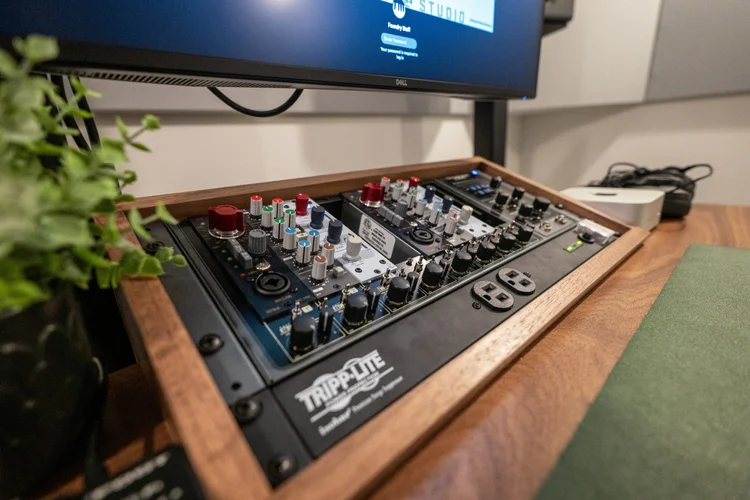 A production suite's interface on a walnut desk