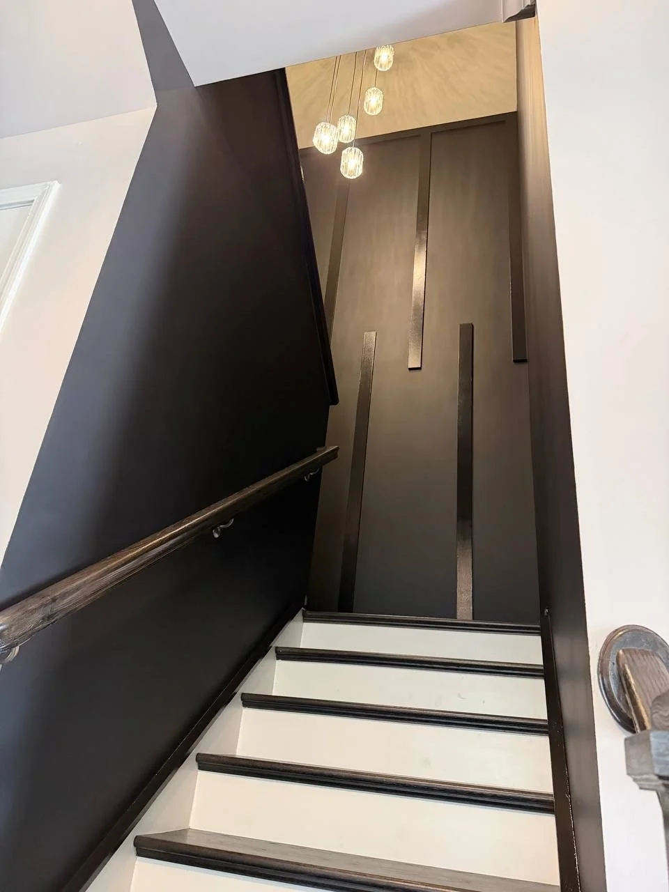 Black slat staircase accent wall with matte and gloss finishes, Charlotte NC