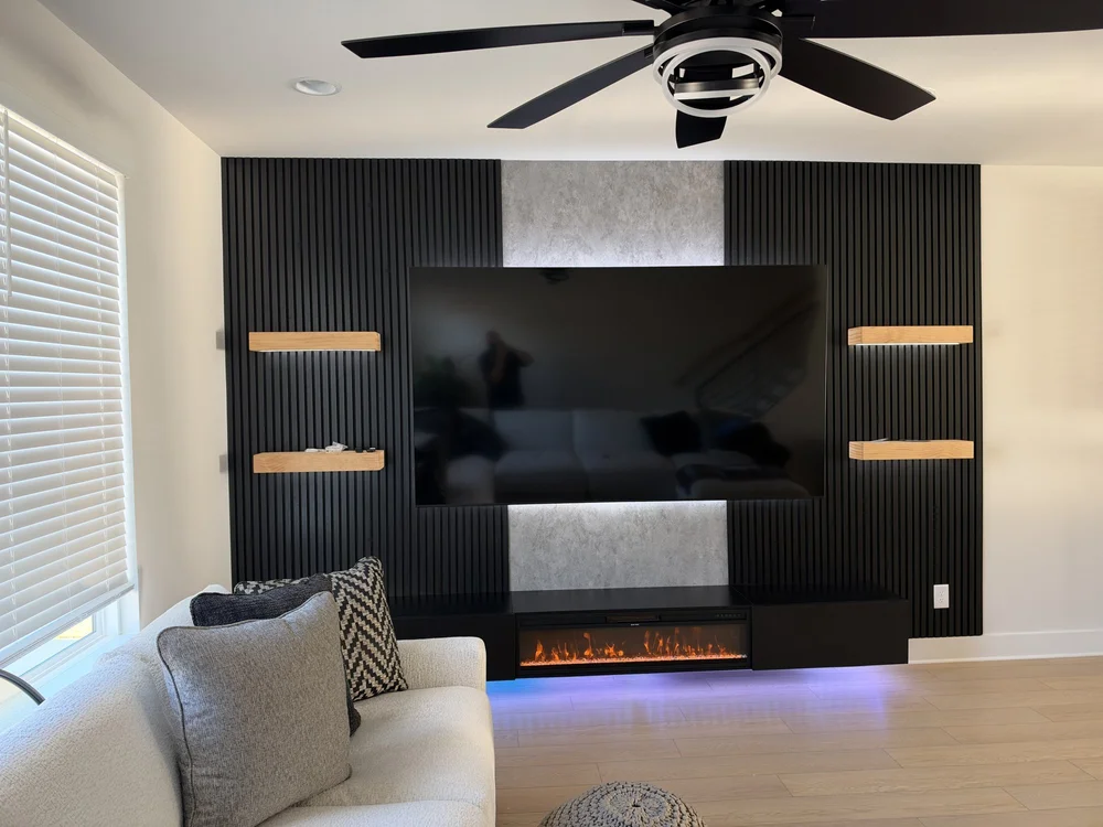 Black slat TV media wall with floating wood shelves and electric fireplace, Charlotte NC